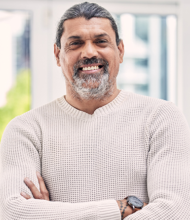 Portrait, smile and senior man with arms crossed in house for positive mindset, relax in retirement.